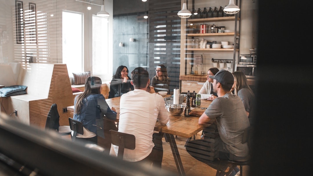 Young adults collaborating around a table in a bright co-working space.